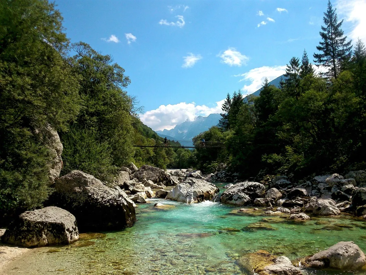 Turquoise Soča river with a suspension bridge and the Julian Alps in the background, Slovenia